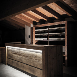 Rifugio del Vino: dietro il banco la scaffalatura per l'esposizione delle bottiglie